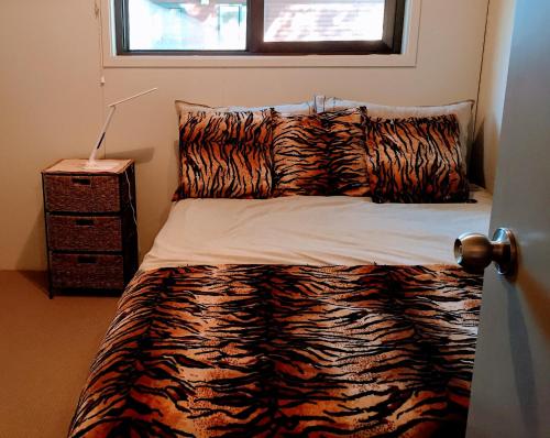 a bedroom with a zebra print bed with a window at Firstcast Turangi in Turangi