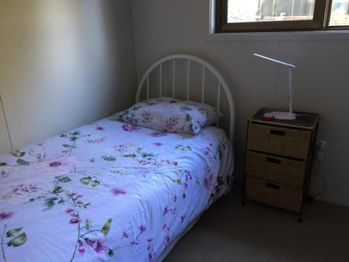 a small bedroom with a bed and a night stand at Firstcast Turangi in Turangi