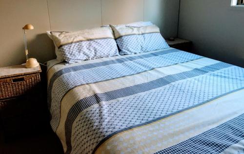a bed with blue and white sheets and pillows at Firstcast Turangi in Turangi
