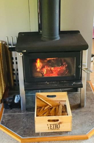 a wood stove with a box on a table at Firstcast Turangi in Turangi