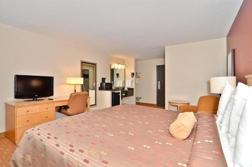 a hotel room with a bed and a television at Clackamas Inn and Suites in Clackamas