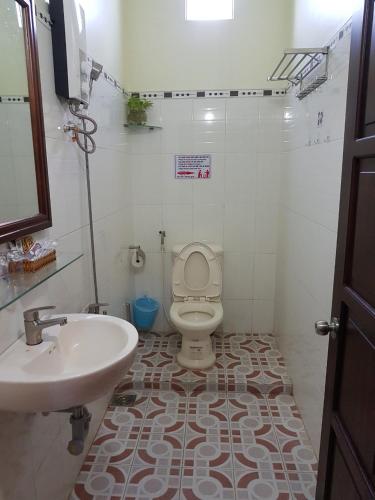 a bathroom with a white toilet and a sink at Hostel Đặng Lợi ホステルダンロイ in Chau Doc