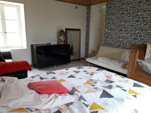 - une chambre avec un grand lit et une télévision dans l'établissement Maison plain pied, 2 chambres, longère typique , fraiche, dans bourg avec tous commerces, à Luçay-le-Mâle