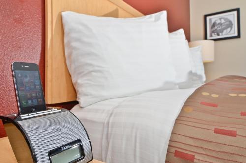 a bedroom with a bed with a speaker next to it at Clackamas Inn and Suites in Clackamas
