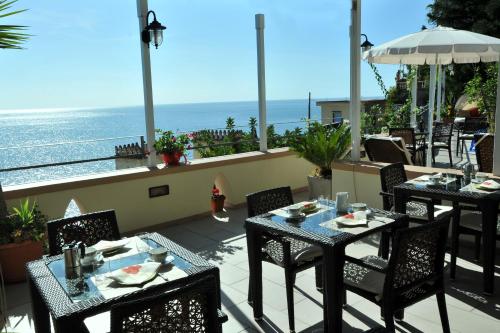 a patio with tables and chairs and the ocean at E Poi...Ravello in Ravello