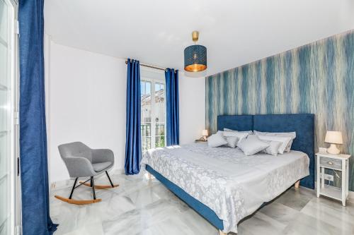 a bedroom with a blue bed and a chair at Luxury Townhouse Golden Mile in Marbella