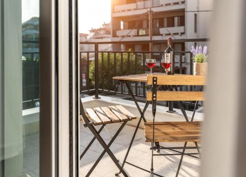 een tafel met twee glazen wijn op een balkon bij TownHall Apartment's in Rhodos-stad