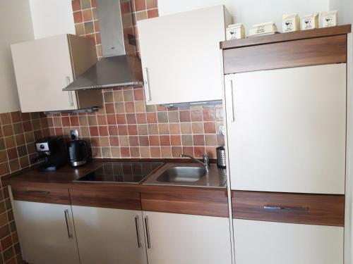 kuchnia z białą lodówką i zlewem w obiekcie Apartament Fala Bryza w Juracie
