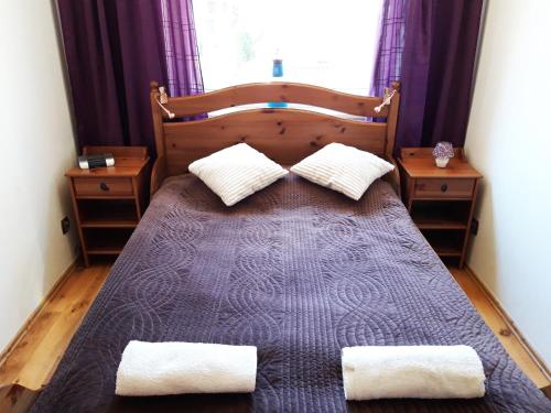 a bedroom with a large bed with two pillows at Apartament Fala Bryza in Jurata