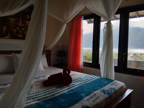 a bedroom with a bed and a large window at Volcano Living in Kintamani