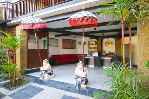 two people sitting under umbrellas in a restaurant at The Swaha Ubud Hotel in Sukawati