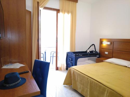 a bedroom with a bed and a table with a hat on it at Villaggio Turistico La Mantinera - Hotel in Praia a Mare