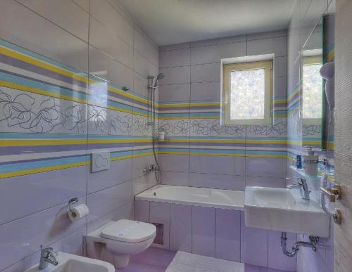 
a bathroom with a toilet, sink, and bathtub at Hotel Modo in Pula
