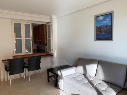 a living room with a white couch and a kitchen at El Teide in Puerto de Santiago