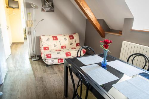 a living room with a table with a vase of flowers on it at Aux Studios du Parc in Plombières-les-Bains