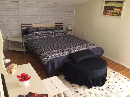 a bedroom with a large bed with a table and a table sidx sidx at Apartman Melody in Sombor