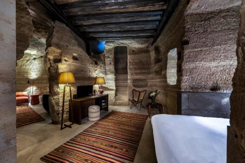 a bedroom with a bed and a table with a lamp at Carus Cappadocia in Goreme