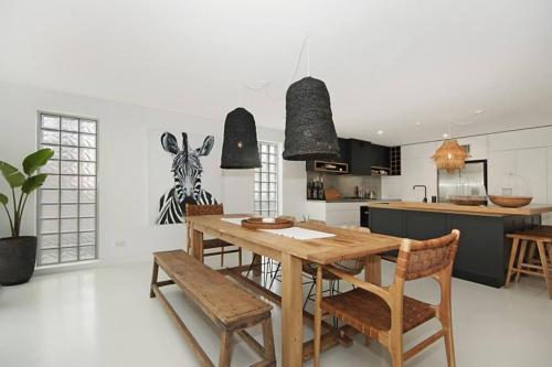 a kitchen and dining room with a wooden table and chairs at Bay Lane Penthouse in Byron Bay