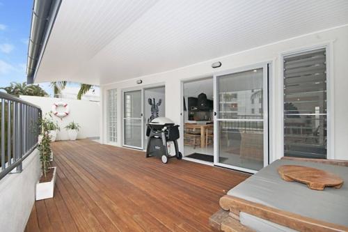 a house with a patio with a baby stroller on a deck at Bay Lane Penthouse in Byron Bay