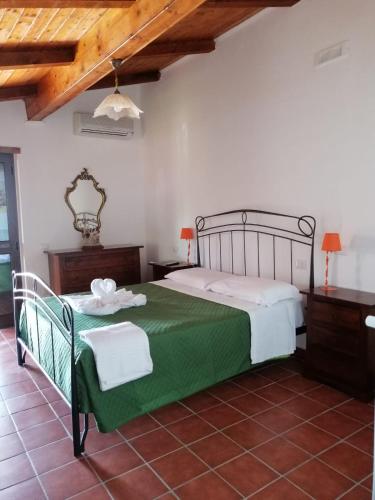 a bedroom with a large bed with a green blanket at Villa Incanto B&B in Caprioli