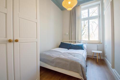 a small bedroom with a bed and a window at Grand Apartments - Lighthouse 200 meters from the beach in Sopot