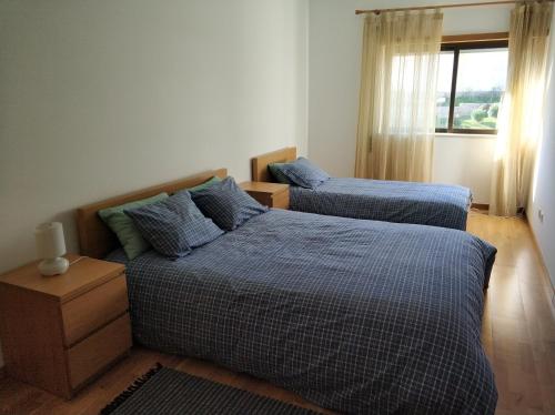 a bedroom with two beds and a window at Cidade da Praia in Figueira da Foz