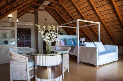 a living room with a table and chairs and a bed at Vila Sol e Sal in Vilanculos