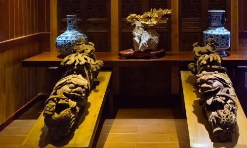 une pièce avec des vases et des statues exposés dans l'établissement Xingping Li River Lodge, à Yangshuo