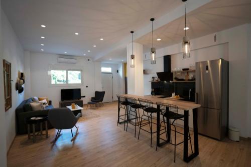 een keuken en een woonkamer met een bar met krukken bij Modern 2bed 2bath loft in Acropolis area in Athene