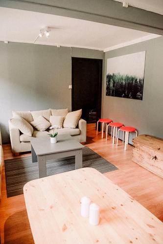 a living room with a couch and tables and chairs at Trolltunga/Folgefonna Camp house in Jondal