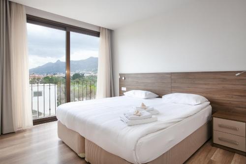 a bedroom with a large bed with a large window at Lavanta Residence in Kérynia