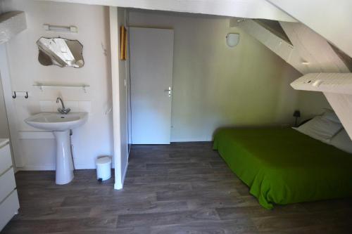 een slaapkamer met een bed, een wastafel en een trap bij Gîte Duras in Souillac