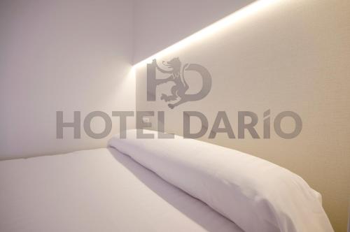a bed with a hotel darico sign on the wall at U-Hotel Darío Lugo in Lugo
