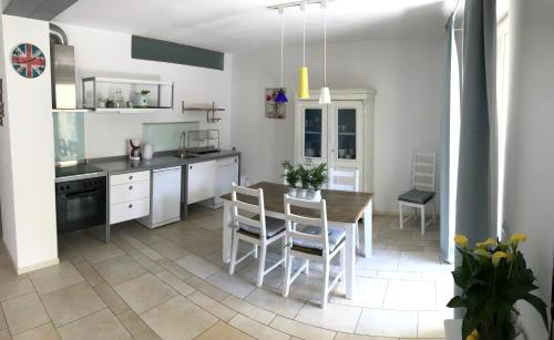 uma cozinha com mesa e cadeiras num quarto em Flowers House em Arco