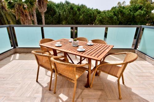 a wooden table and chairs on a balcony at Baldacchino Holiday Villas in Mellieħa