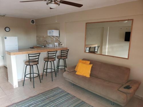 un salon avec un canapé et une cuisine avec un comptoir dans l'établissement Cozy apartment near the beach #1, à Fajardo