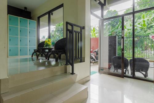 una habitación con ventanas y una mesa con flores. en RedDoorz @ Malalayang 2 Manado, en Manado