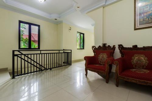 a living room with two chairs and a staircase at RedDoorz @ Malalayang 2 Manado in Manado