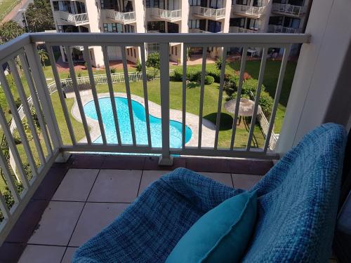 a balcony with a view of a swimming pool at Umdloti Beach Apartment in Umdloti