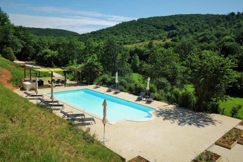 - une vue sur la piscine bordée de chaises et d'arbres dans l'établissement Gîte Manseng, à Souillac