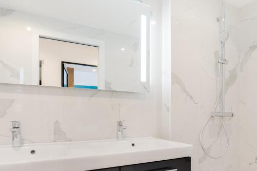 une salle de bain blanche avec un lavabo et un miroir dans l'établissement Loft Design for 8 people in Heart of Paris, à Paris