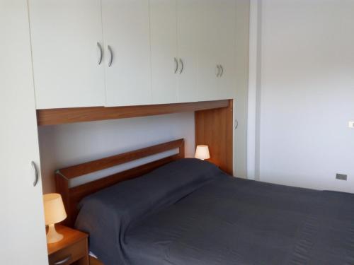 マルティンシクーロにあるAppartamento Capriのベッドルーム(青いベッド1台、白いキャビネット付)