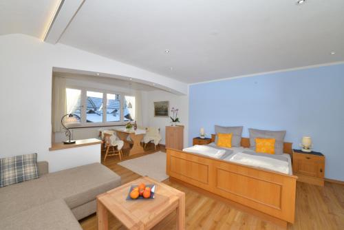 a living room with a bed and a table at Gästehaus Maxheim in Oberstdorf