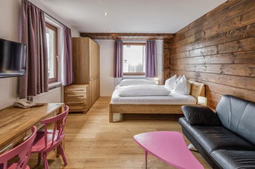 pokój hotelowy z 2 łóżkami i kanapą w obiekcie Hotel Daneu w mieście Nüziders