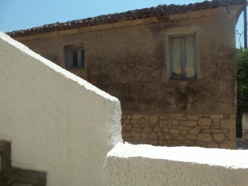 a building with a white wall and two windows at Arellis in Afitos