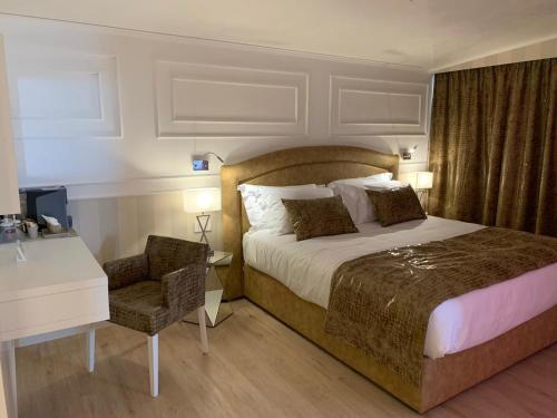 1 dormitorio con 1 cama con escritorio y silla en Hotel Alexander, en Milano Marittima