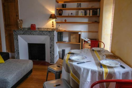 - une salle à manger avec une table et des assiettes dans l'établissement Ingres by Cocoonr, à Toulouse