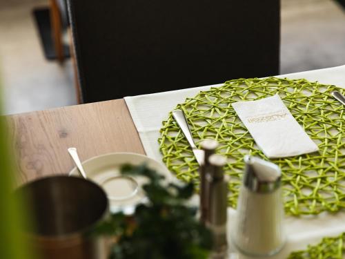 a table with a green plate with a napkin on it at Hotel Auszeit in Pertisau