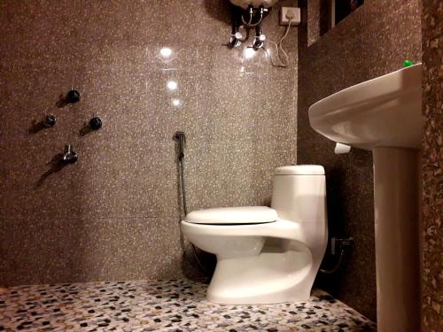 un baño con inodoro y lavabo en FRATERNITY HOMESTAY, en Darjeeling