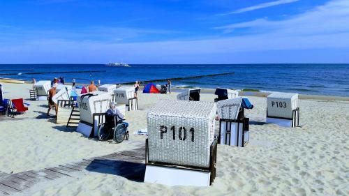 a beach with chairs and people on the beach at Strandburg, das smarte Penthouse in ÜckeRitz mit PKW Stellplatz! in Ueckeritz